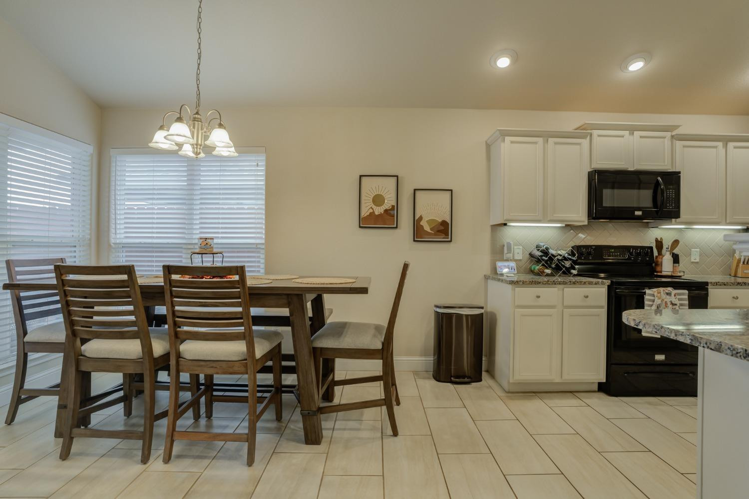 3605 Ridgely Lubbock, TX 79407 - Photo 12 of 36 a kitchen with stainless steel appliances granite countertop a stove a sink a microwave a dining table and chairs