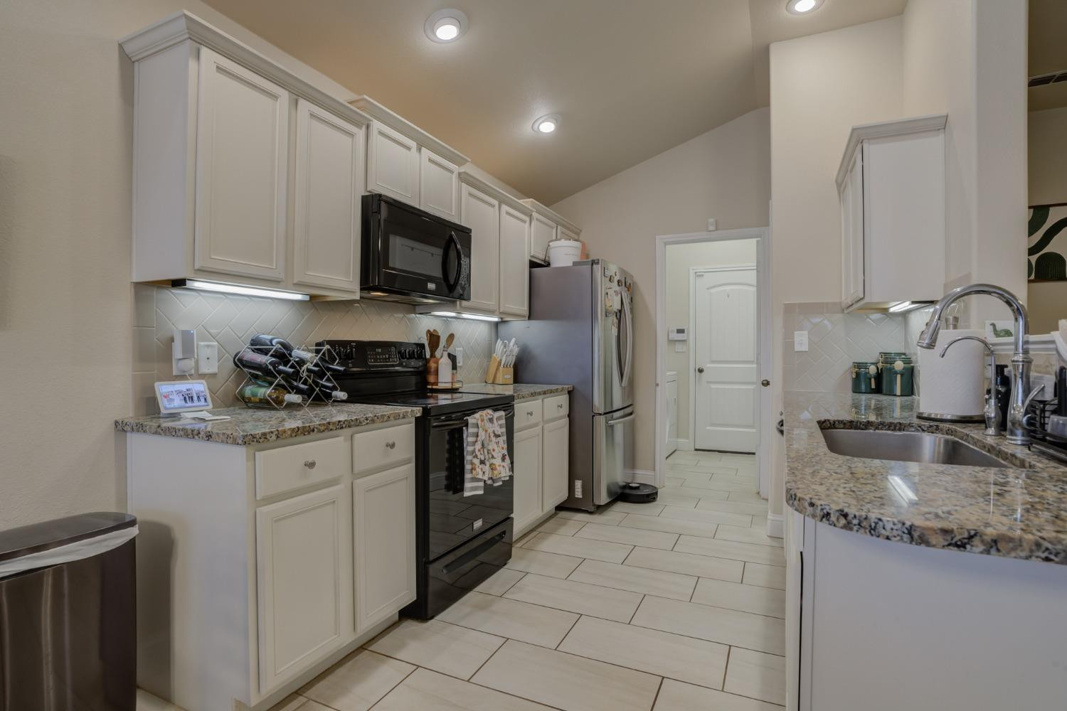 3605 Ridgely Lubbock, TX 79407 - Photo 13 of 36 a kitchen with stainless steel appliances granite countertop a sink stove and refrigerator