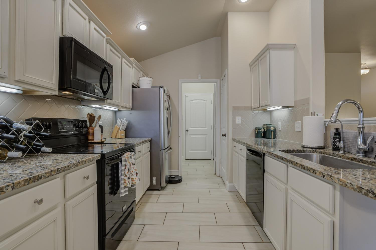 3605 Ridgely Lubbock, TX 79407 - Photo 15 of 36 a kitchen with stainless steel appliances granite countertop a sink stove and cabinets