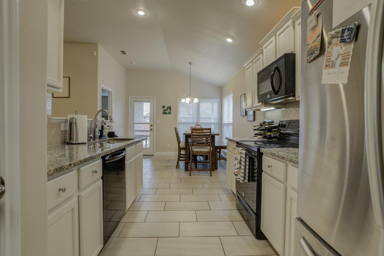 3605 Ridgely Lubbock, TX 79407 - Photo 17 of 36 a kitchen with stainless steel appliances granite countertop a refrigerator and a stove top oven