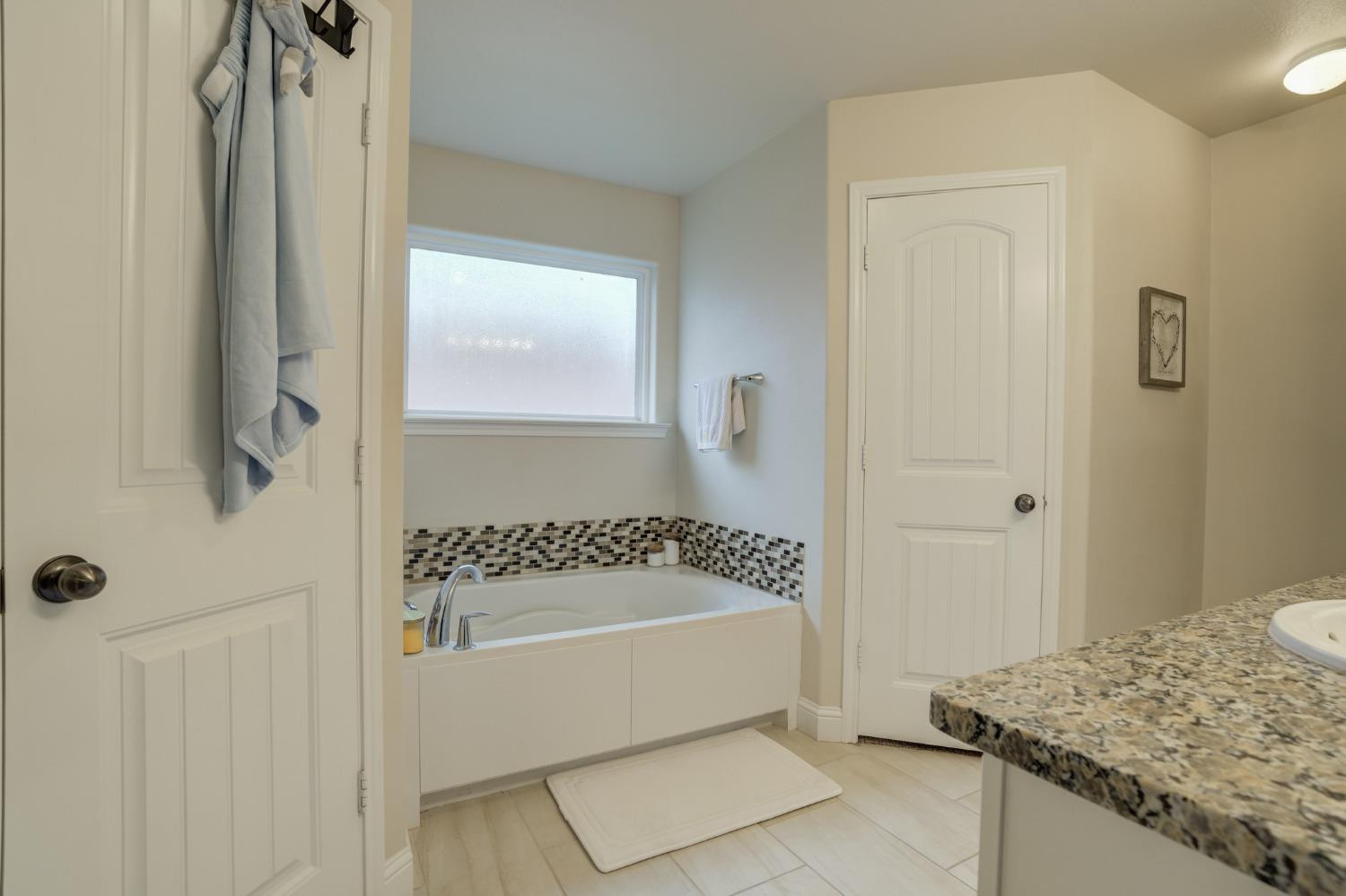 3605 Ridgely Lubbock, TX 79407 - Photo 24 of 36 a bathroom with a granite countertop bathtub a sink and a shower
