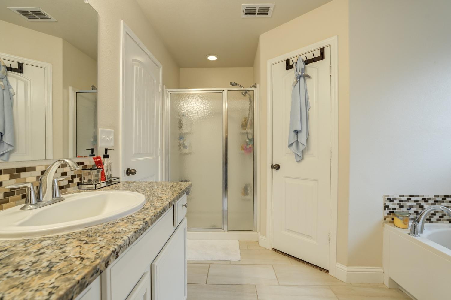 3605 Ridgely Lubbock, TX 79407 - Photo 27 of 36 a bathroom with a granite countertop shower sink and mirror