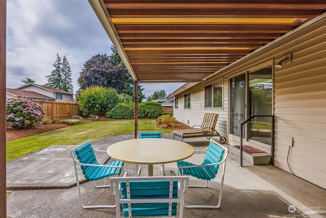 a view of a house with backyard and sitting area