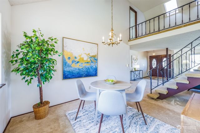 a view of a dining room with furniture and a chandelier