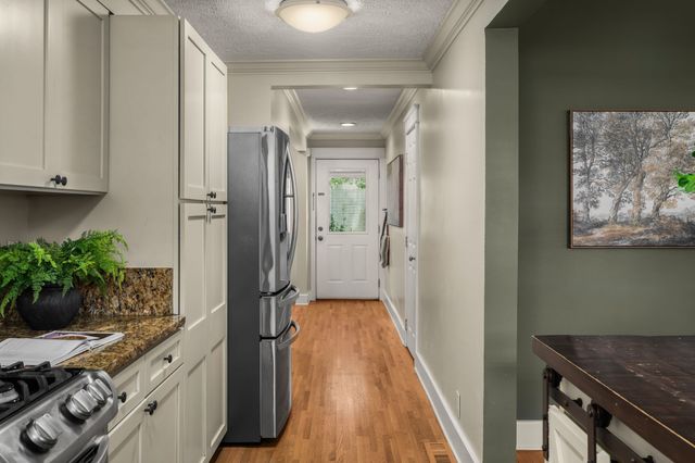 a view of a hallway and a dining room with wooden floor