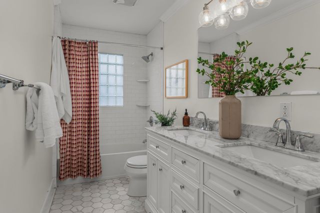 a bathroom with a granite countertop sink a toilet a mirror and shower