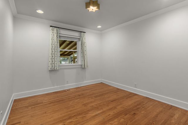 a view of room with window and wooden floor