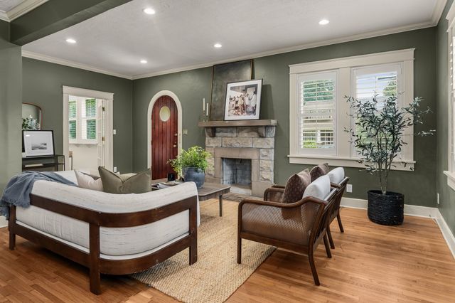 a living room with fireplace furniture and a large window