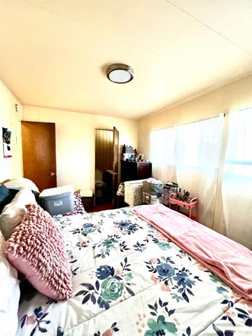 a bedroom with a bed and dresser with mirror