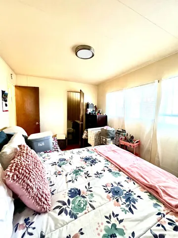 a bedroom with a bed and dresser with mirror