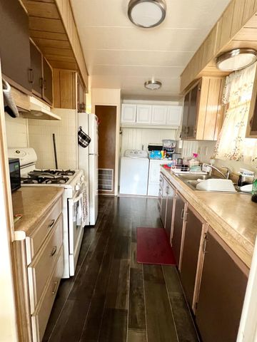 a kitchen that has a lot of cabinets a sink and appliances