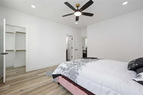 a bedroom with a large bed and a ceiling fan