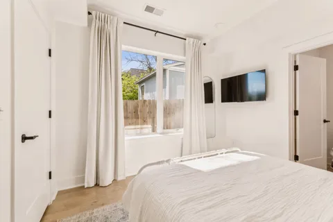 a bedroom with a bed and a flat screen tv
