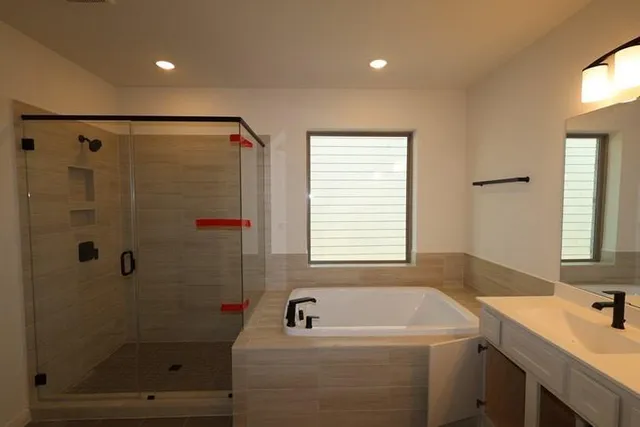 a bathroom with a tub a sink a window and a shower
