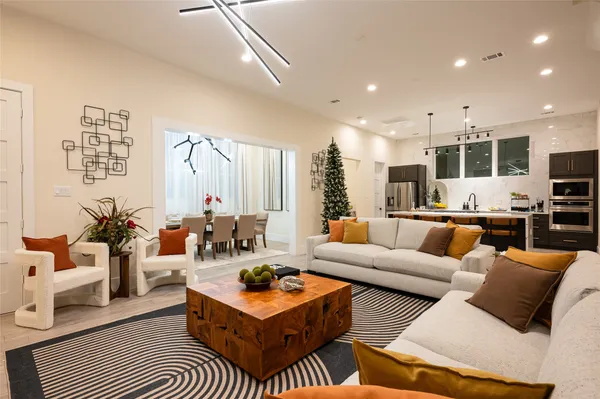 a living room with furniture kitchen view and a large window