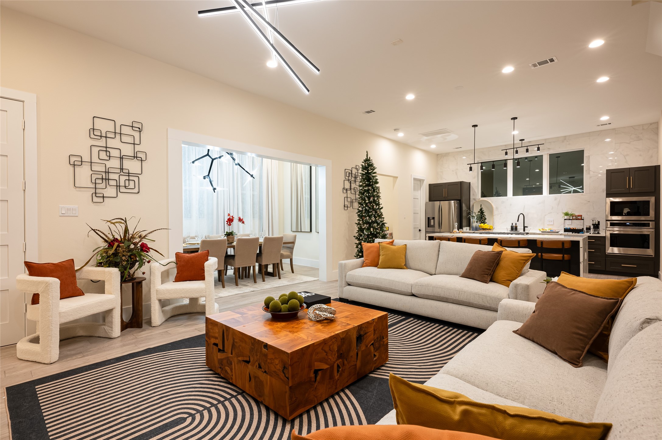 a living room with furniture kitchen view and a large window
