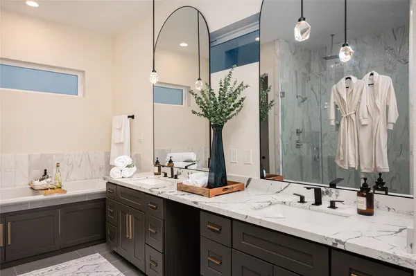 a bathroom with double vanity sinks a vanity and a large mirror