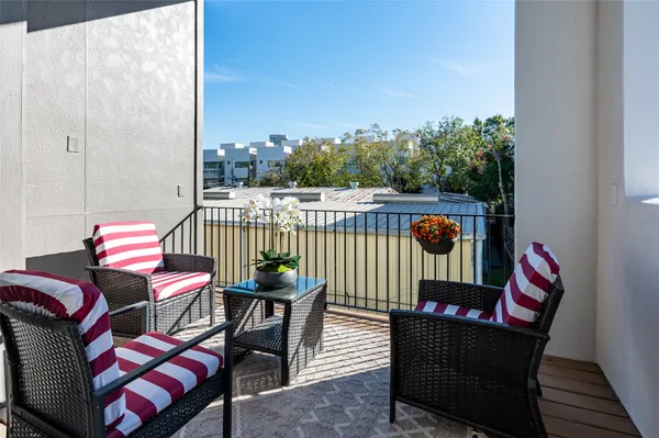 a balcony with chairs and flower pot