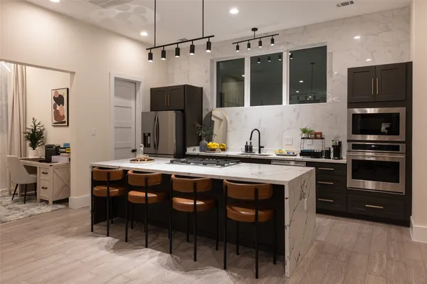 a kitchen with stainless steel appliances granite countertop a sink refrigerator and cabinets