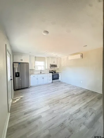 a view of a kitchen with wooden cabinet and a refrigerator
