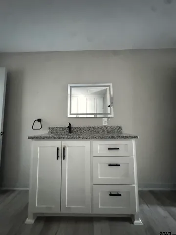 a bathroom with a granite countertop sink and a mirror