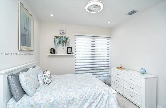 a living room with furniture and a refrigerator