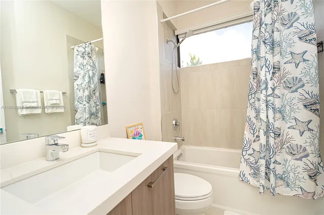 a living room with furniture a rug and kitchen view