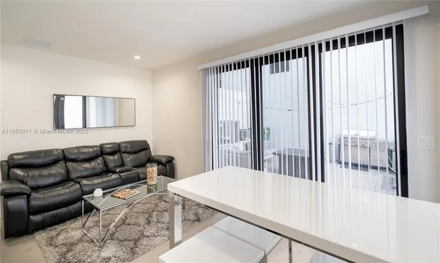 a living room with furniture and a floor to ceiling window