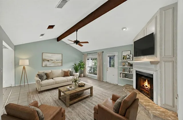 a living room with furniture a fireplace and a flat screen tv