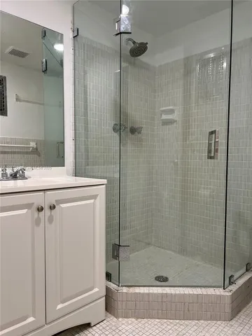 a bathroom with a shower and a sink a mirror