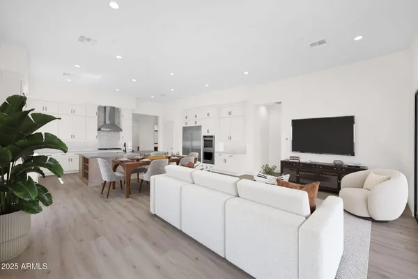 a view of an empty room with wooden floor and windows