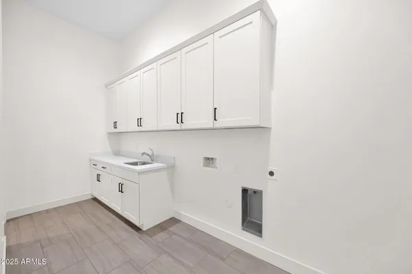 a view of a house with small yard plants and large tree