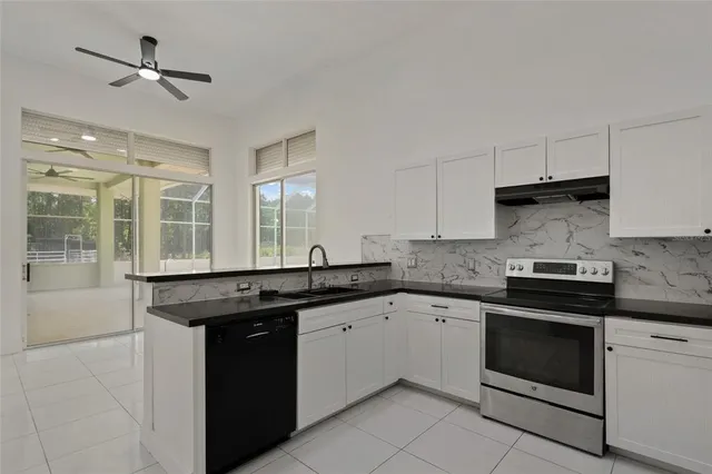 an empty room with windows and fireplace