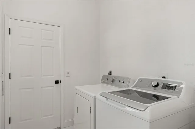 a view of a swimming pool with a yard and large trees