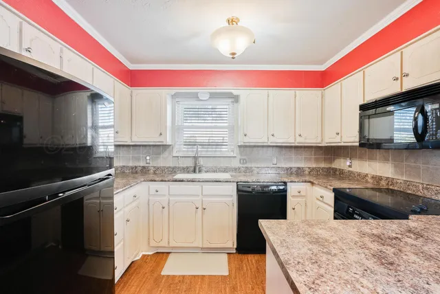 a kitchen with a sink dishwasher a stove a microwave oven and cabinets