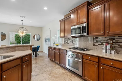 a kitchen with stainless steel appliances granite countertop a sink stove and microwave