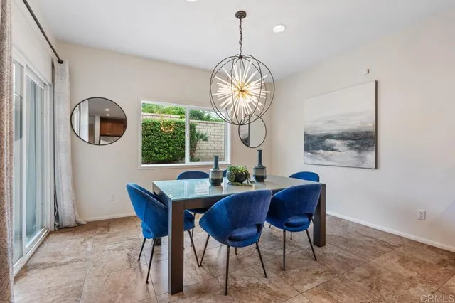 a dining room with chandelier fan and wooden floor