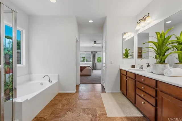 a spacious bathroom with a tub sink and mirror