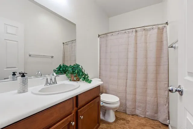 a hallway with a dining table and paintings on the wall