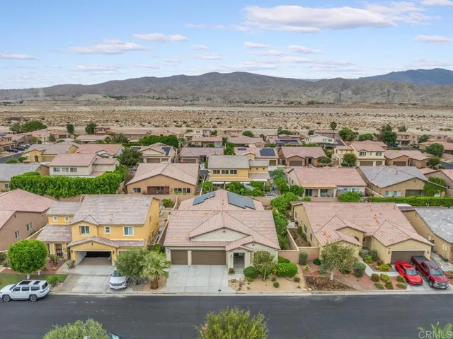 an aerial view of residential houses with outdoor space and city view
