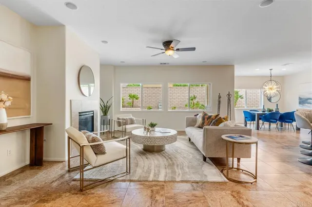a living room with furniture a fireplace and a large window