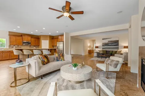 a living room with furniture kitchen view and a chandelier
