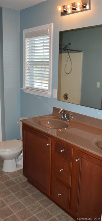 657 Shellbark Drive Concord, NC 28025 - Photo 11 of 24 a bathroom with a sink a toilet and a window