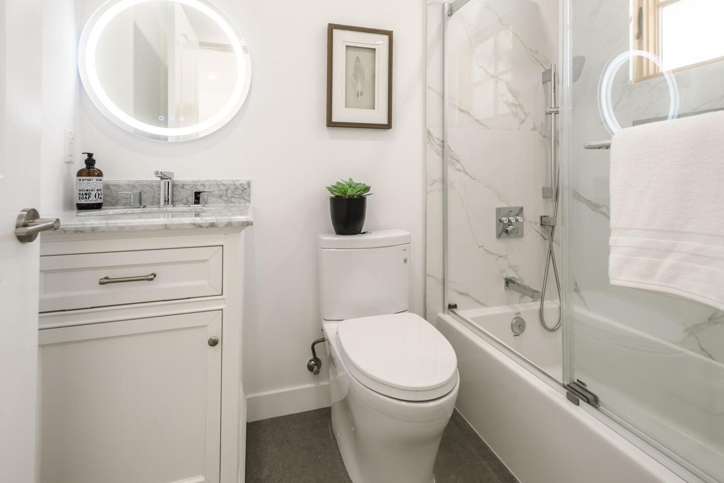 611 Bayview Avenue Millbrae, CA 94030 - Photo 17 of 34 a bathroom with a toilet a sink a mirror a bathtub and vanity