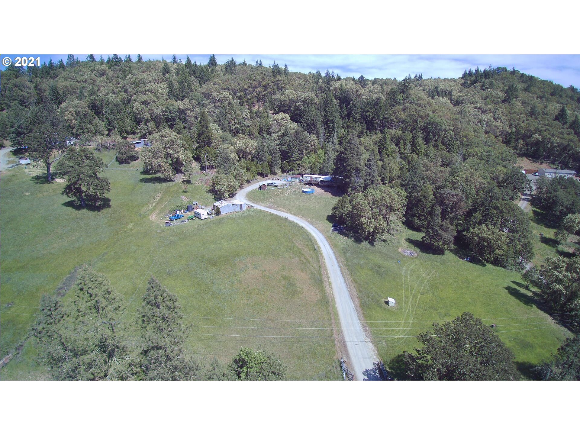 1827 Spring Brook Road Myrtle Creek, OR 97457 - Photo 1 of 15 a picture of a field with trees in the background