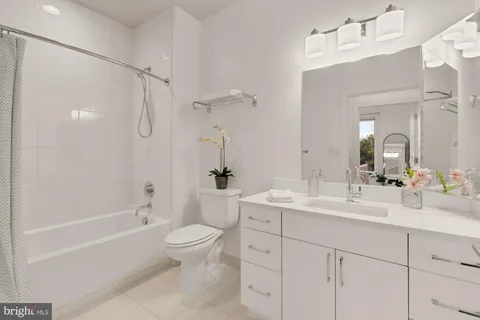 a bathroom with a double vanity sink toilet mirror and shower