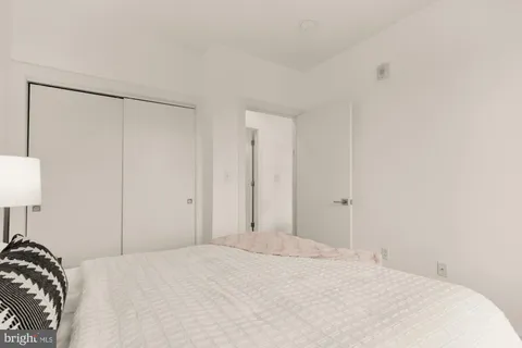 a view of a bedroom with a bed and a lamp