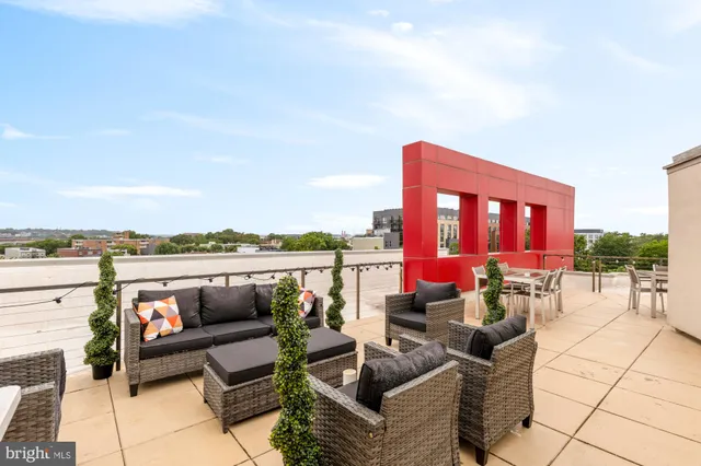an outdoor living room with patio a couch and chairs