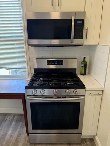 a stove top oven sitting inside of a kitchen