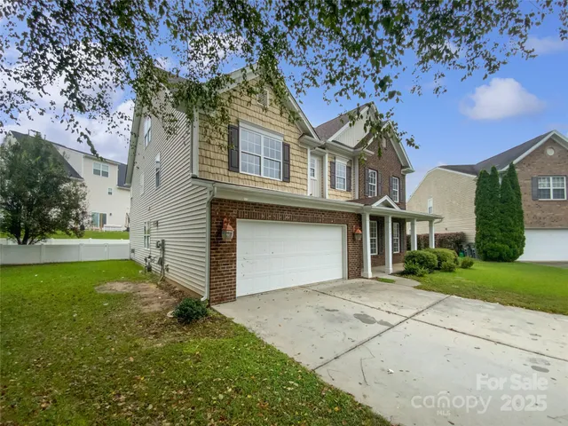 a front view of a house with a garden and trees